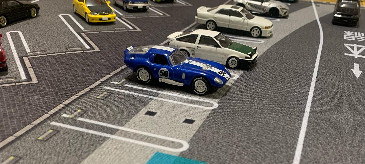 Model cars on a parking lot with a blue car in focus