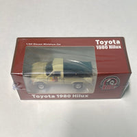 BM Creations 1/64 Toyota Hilux, Ivory RHD w/ Extra Wheels & Bumpers