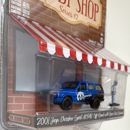 Greenlight 1/64 The Hobby Shop 2001 Jeep Cherokee Sport Mopar Off-Road W/ Race Car Driver Blue